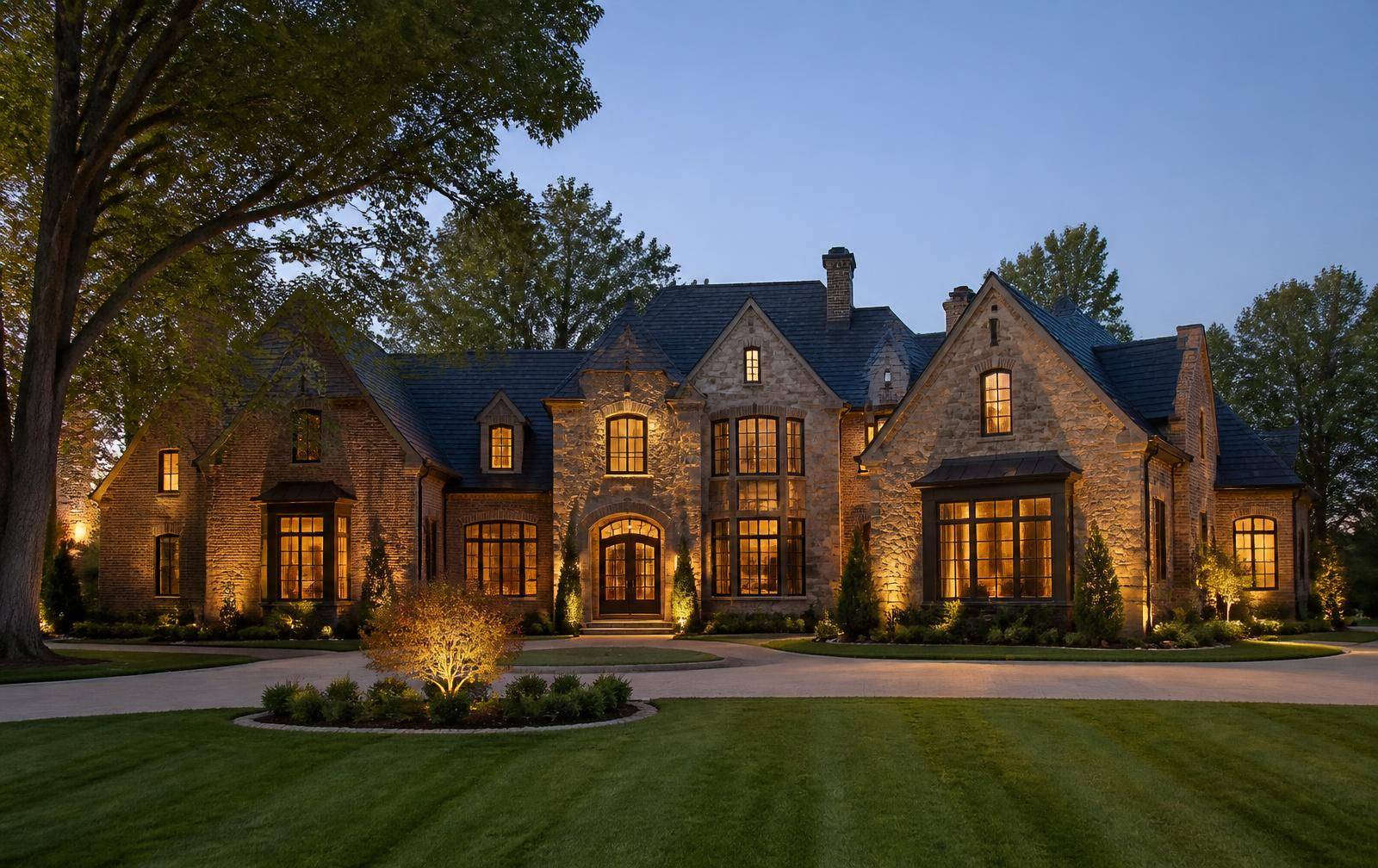 Brick-and-stone estate home at dusk in the Ballantyne golf community